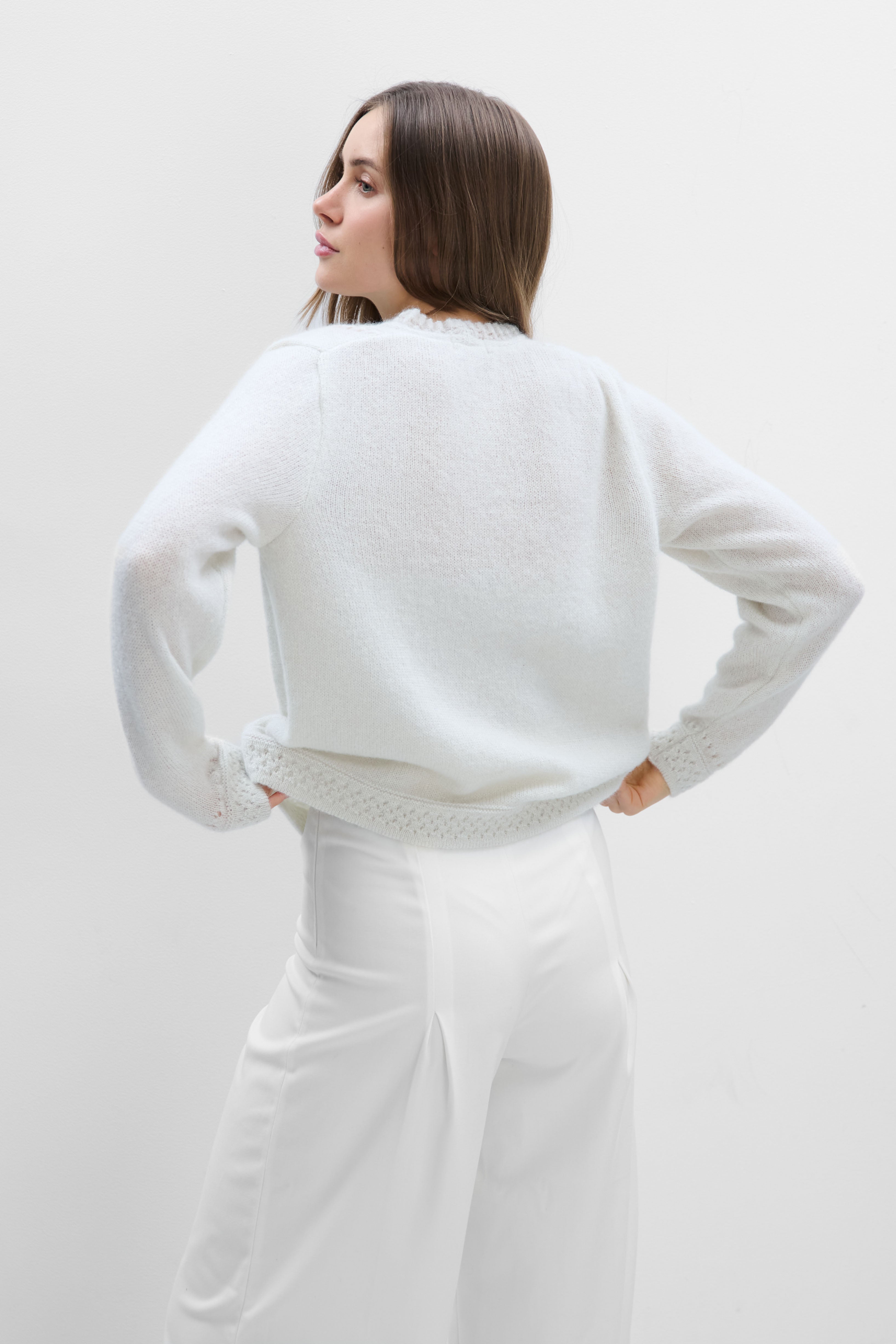 A delicate buttoned cardigan made of ecru alpaca wool and girl's wool.